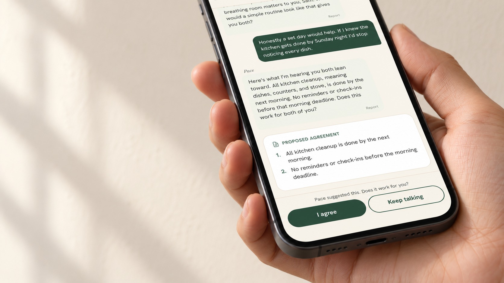 A hand holding a phone showing their proposed shared agreement